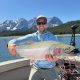 Man holding rainbow trout on fishing trip with Canmore fishing Adventures