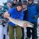 Group of people catching a fish during the Ice Fishing trip by Canmore Fishing Adventures